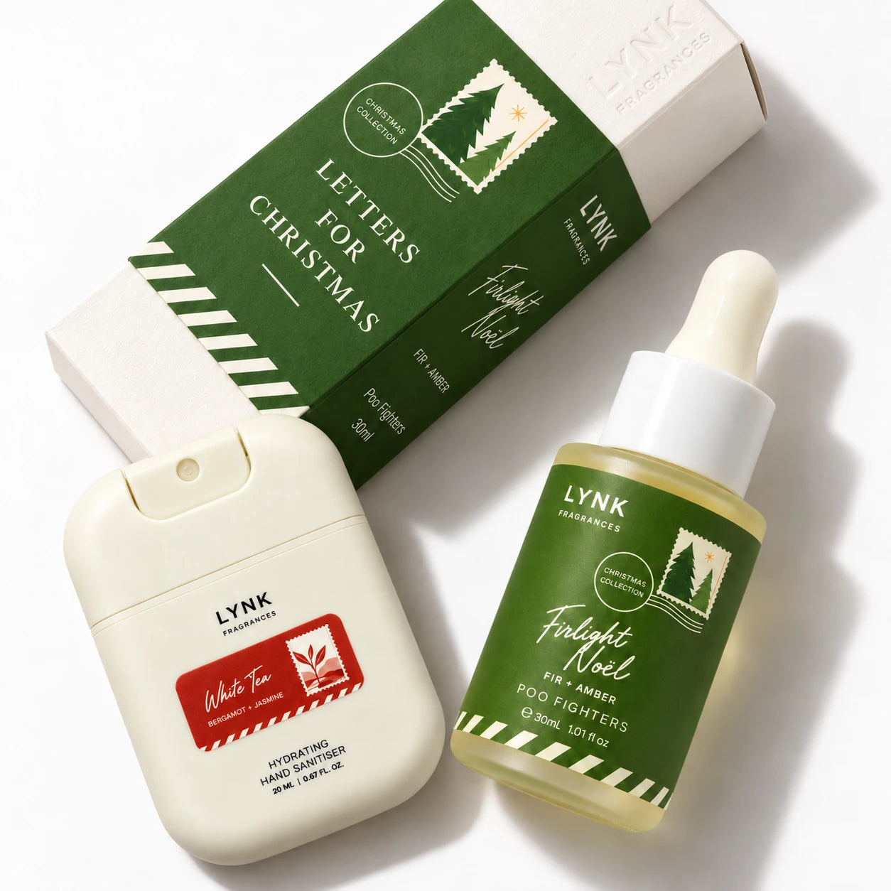 White Tea pocket sanitiser beside Firlight Noël Poo Fighters and its carton in a diagonal product grouping.