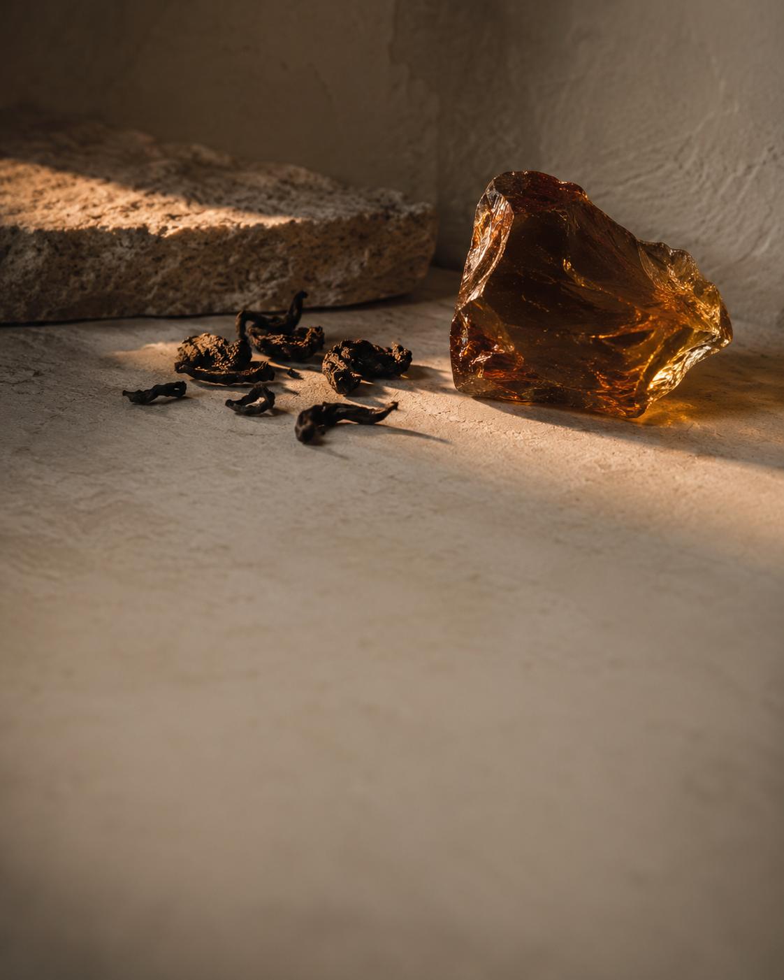 Oolong d'Celeste material still — loose oolong leaves and amber glass, warm dusk glint