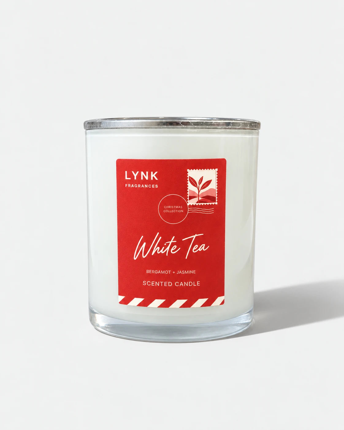 White Tea candle on a pale studio ground with a directional shadow.