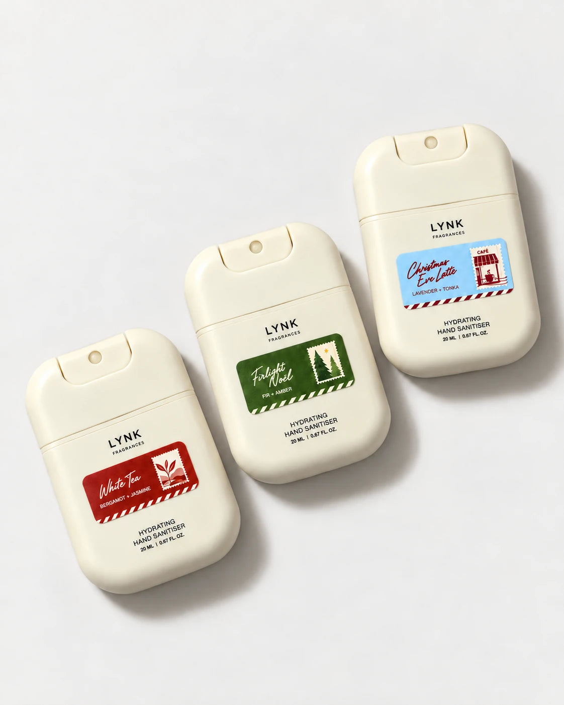 The three Christmas pocket hand sanitisers arranged diagonally with their red, green and blue scent labels.